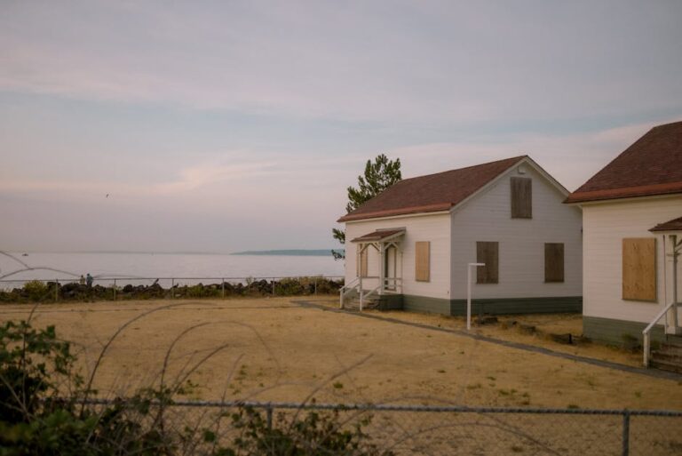 A serene view of abandoned cottages on Seattle's coastline, captured at dusk.