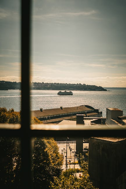 Serene view of a ferry crossing Puget Sound from Seattle waterfront window.